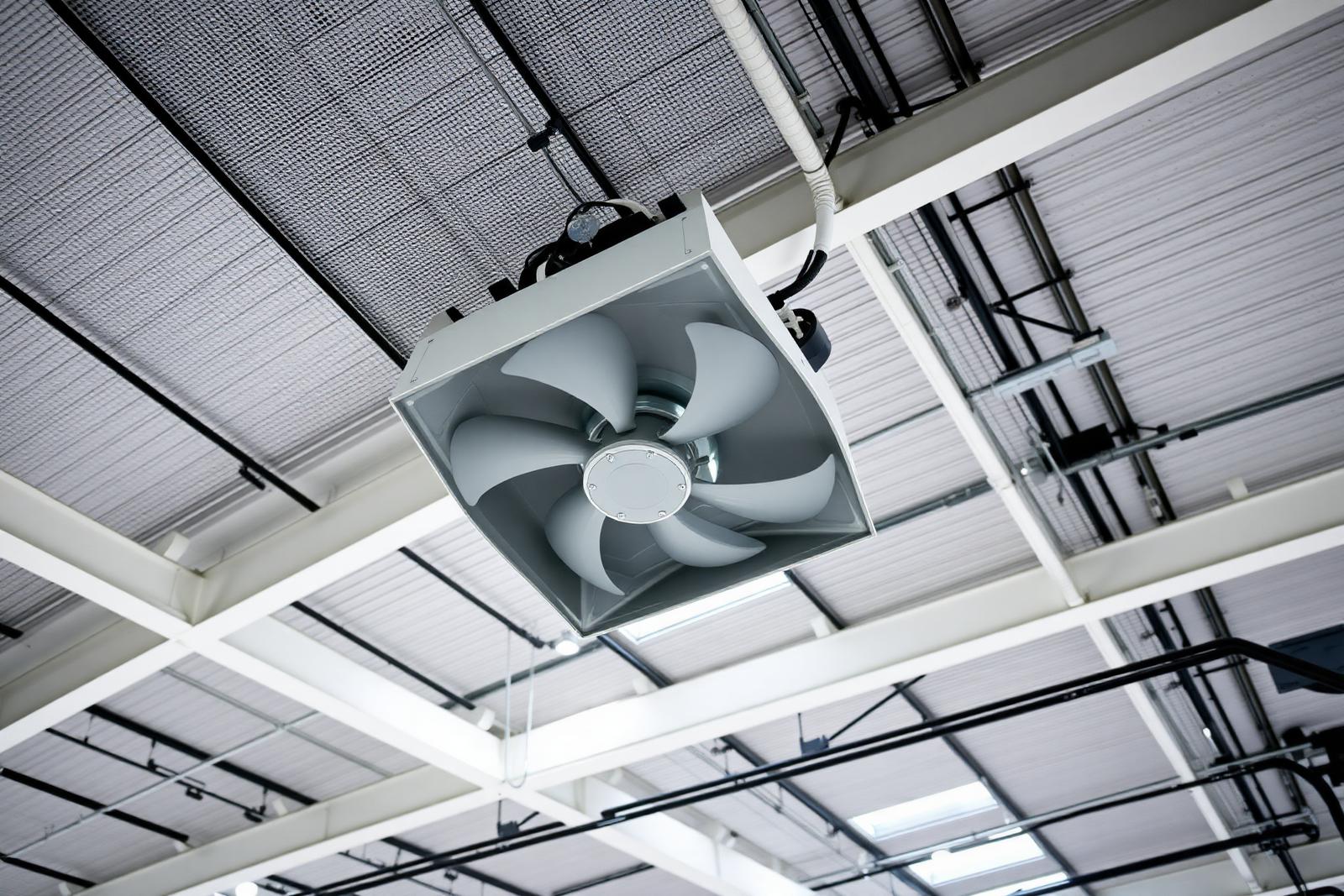 Destratificateur d'air installé sous toiture d'un bâtiment industriel